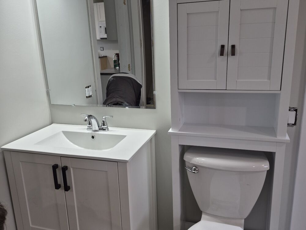 A finished bathroom with new vanity, mirror and fixtures