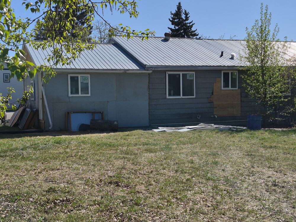 The duplex exterior before renovation, with siding removed