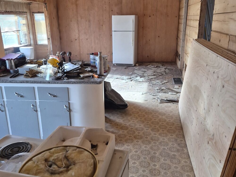 The original kitchen with dated cabinets and wood ceiling